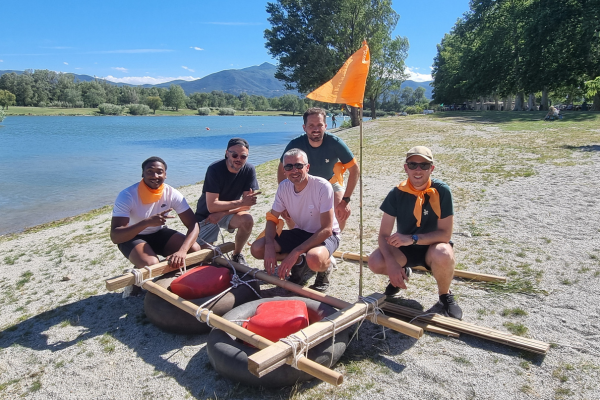 un groupe de personne qui posent derrière leur radeau construit à partir de bidon, chambre à air et bambou.